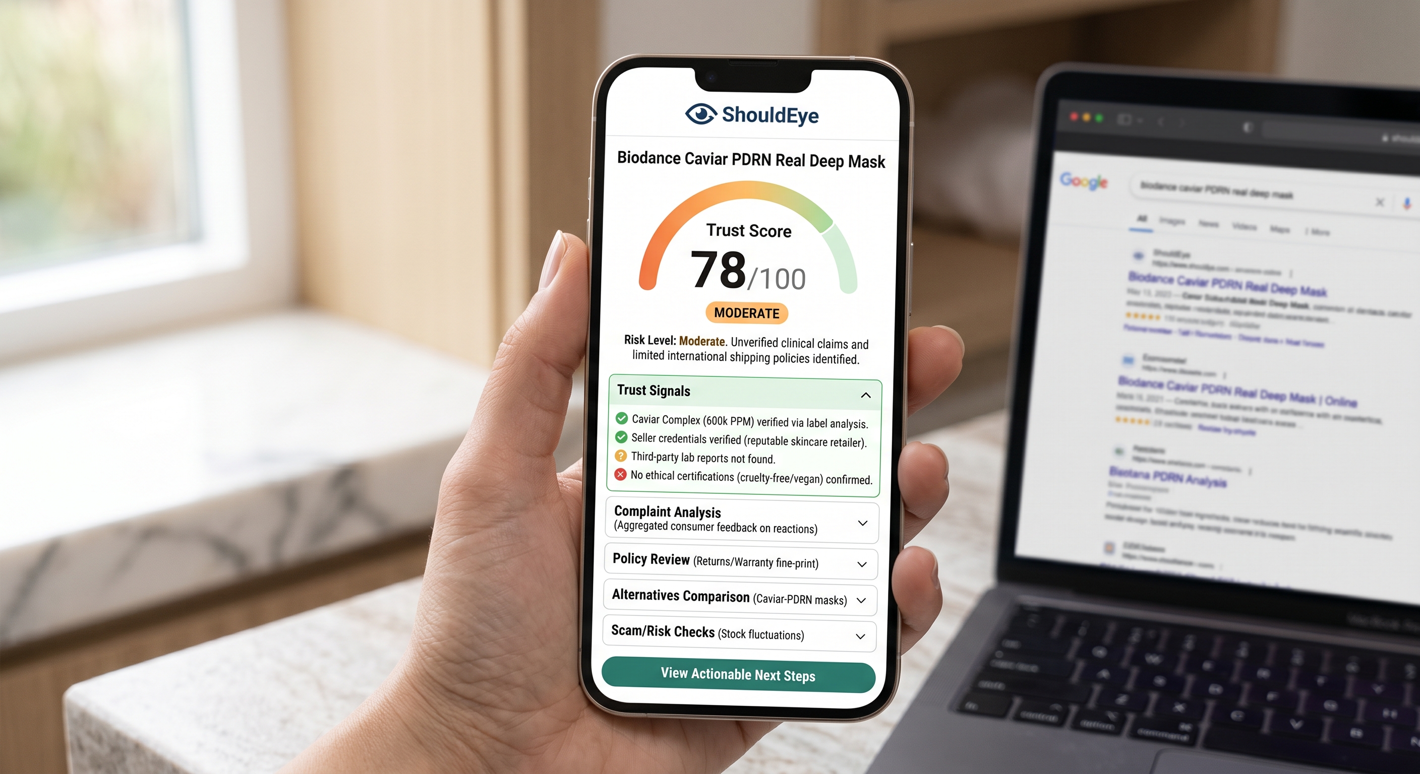 A hand holds a smartphone showing the ShouldEye app with a trust score of 78 out of 100, next to a laptop.