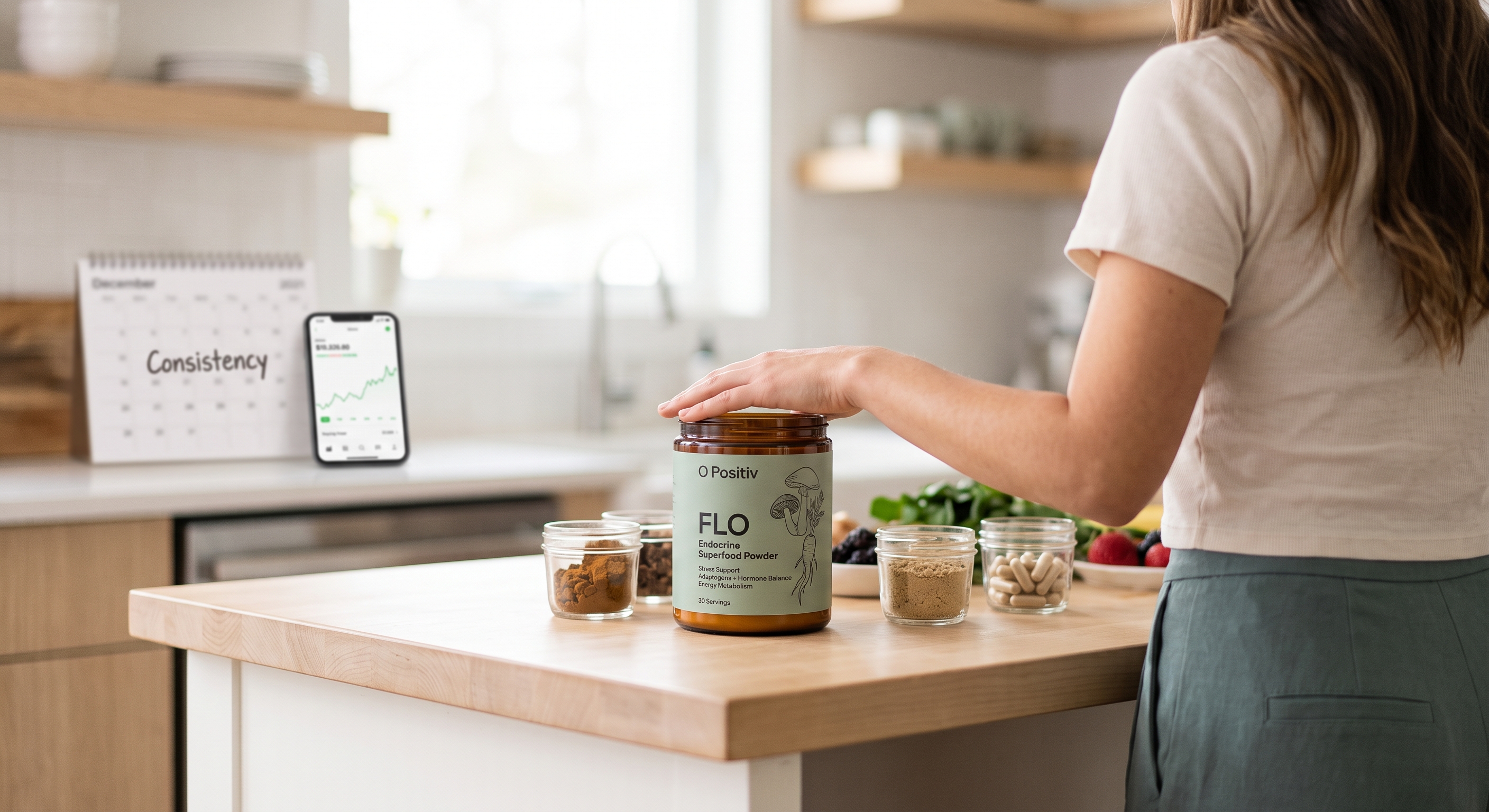 A woman in a kitchen places her hand on a jar of O Positiv FLO powder, surrounded by ingredients and a calendar with a phone.