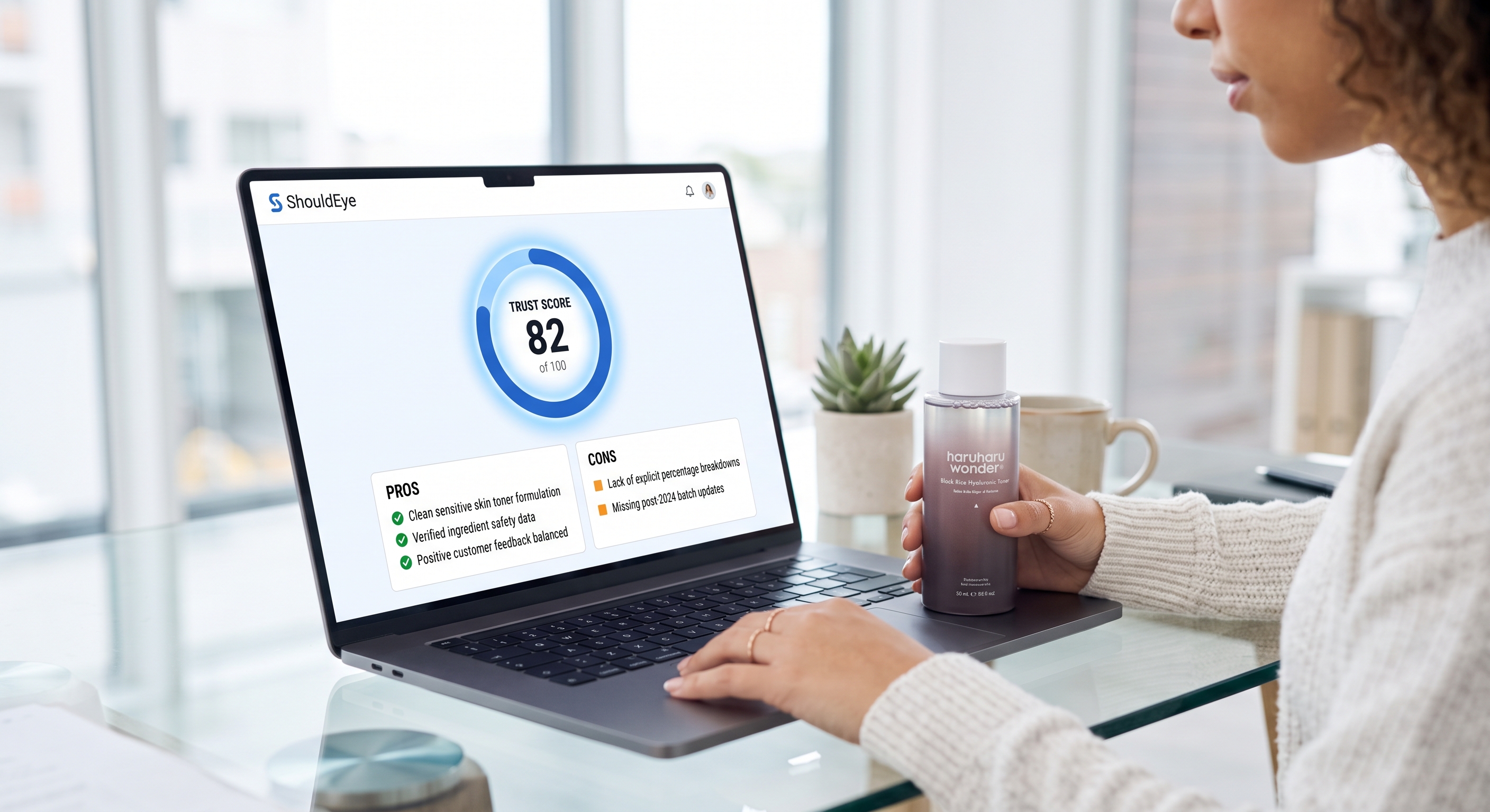 A person holding a Haruharu toner bottle looks at a laptop screen displaying a product integrity assessment.