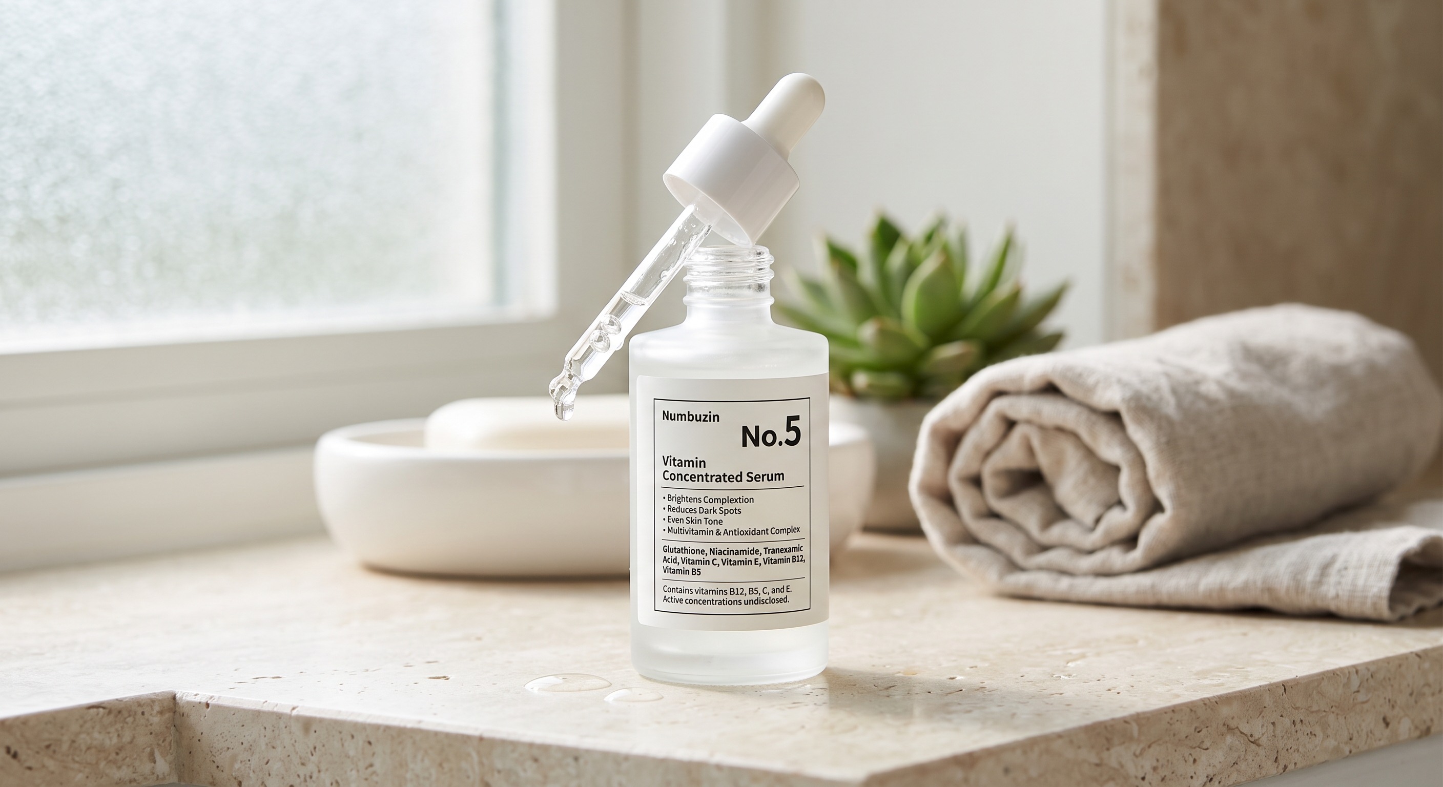 A close-up photograph of a Numbuzin No. 5 Vitamin Concentrated Serum bottle on a marble bathroom counter with a dropper.
